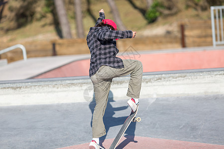 年轻人在滑冰场跳跃游戏娱乐速度男性滑冰闲暇运动城市街道诡计图片
