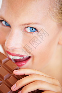 甜美的年轻女人享受着美味的巧克力 笑一笑 - 她很好吃 (笑声)图片