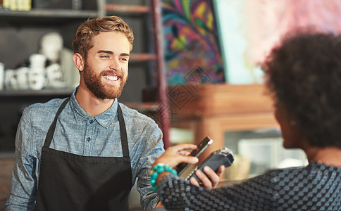 无纸交易 是唯一的支付方式 咖啡师从咖啡馆的客户那里拿智能手机付款图片