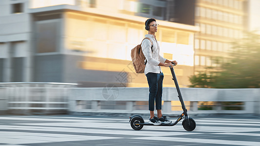 电动滑板车 快速旅行或商务人士在伦敦的城市 街道或道路上使用交通工具 早上骑自行车上班 办公室或大学的员工 工人或设计师黑人图片