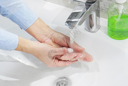 在洗浴盆 清洁和卫生间用肥皂或凝胶在自来水下洗手 妇女双手穿蓝衬衫卫生感染合金细菌泡沫洗澡蓝色女性龙头浴室图片