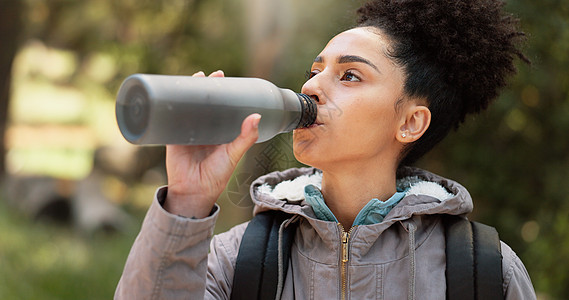 在自然 森林和山地公园徒步旅行的女性饮用水 以实现健康的生活方式 健康和户外探险 年轻的黑人女孩 水瓶和徒步旅行 自由和在早晨的图片