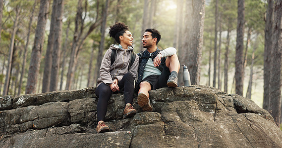 自然 远足和一对夫妇在森林中的探险小径上放松 坐在岩石上 健康 快乐的男人和女人指着自然景观 同时在树木 健身和自由的树林中放松图片
