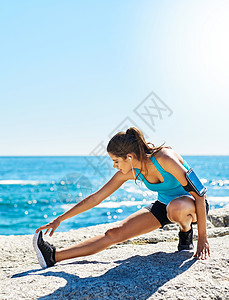 准备行动 一个年轻女子在跑步前伸展长臂图片