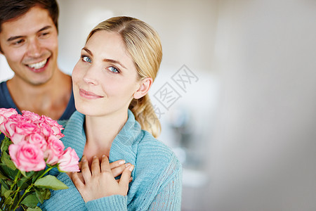 绽放的爱 一个深情的年轻人给他美丽的年轻妻子一束粉红玫瑰图片