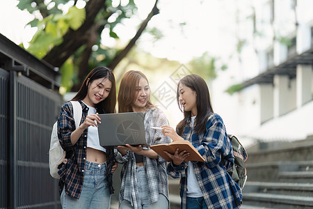 有朋友的美丽的年轻亚裔女大学生在户外 在大学校园工作的大学生学习男性青年学校女性笔记本女士教育团体电脑图片