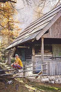 垂直的照片 微笑的女登山者 与太阳眼镜休息在山顶小屋图片