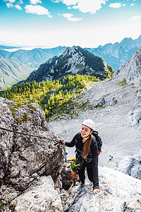 在阿尔卑斯山脉的足迹上登山的caucasians女性登山者垂直照片图片