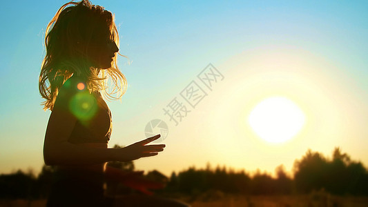 图 一个美丽 运动的女孩的轮廓 长着金发 在夏天做运动 拳击 飞腿 在日落时跳跃 在蓝天 阳光下跳跃数字场地活动绑腿跳绳假期力量图片