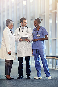 现代技术在他们的决策中起着重要作用 一起使用数字平板电脑的医疗团队图片