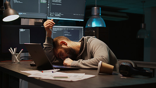 信息技术开发者打哈欠和在办公桌上睡着了图片