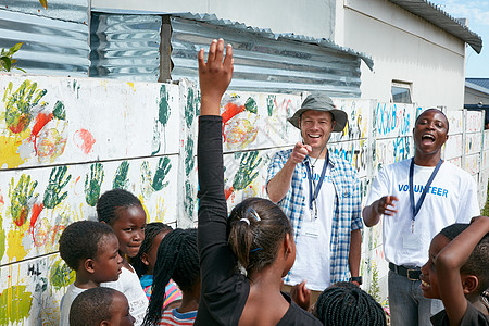 问吧 志愿工作者在社区外展活动中向一群儿童讲话 (请问 志愿者)图片