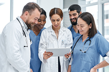 使用对患者数据的共享访问权限 一群医生在医院一起使用数字平板电脑图片