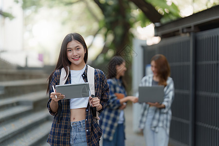 有朋友的美丽的年轻亚裔女大学生在户外 在大学校园工作的大学生女性学习休闲装朋友们教育青年学校成人班级笔记本图片