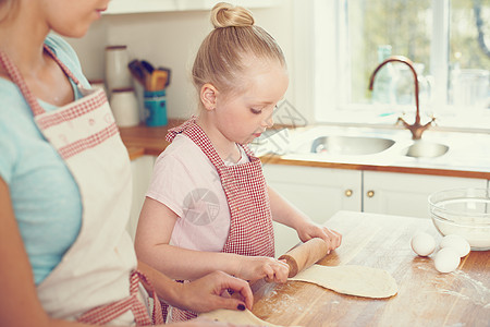 甜美的小女孩和妈妈一起在厨房里烘烤 她太可爱了图片