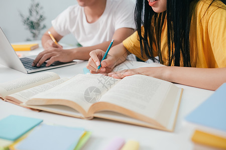 近身的亚裔学生正在阅读书本和学习 并一起教学友谊知识老师咨询报告学费演讲中学校园考试图片