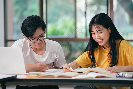 一个亚裔学生正在阅读书本和学习 一起教书老师学费团队友谊演讲学校校园朋友们青少年同学图片