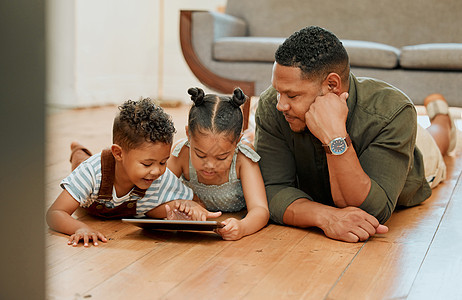 一个快乐的混血家庭 三人一起放松 躺在休息室的地板上 在使用数字平板电脑流时 爱黑人单亲父母与他的孩子建立联系儿子技术房间成人女图片
