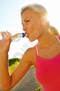 健康的生活 一个漂亮的年轻女子 在运动用瓶子装饮用水中图片