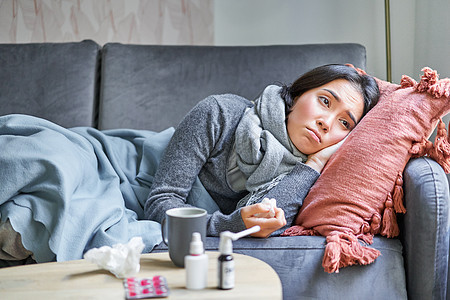 生病 悲伤的韩国女人躺在沙发上 感觉身体不适 感冒 流感和体温升高 看起来心烦意乱 正在服药女士疾病弱点女性感染成人房子长椅症状图片