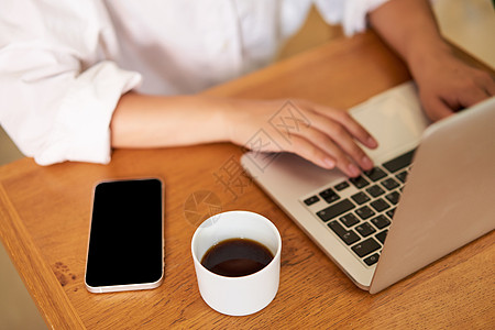 在笔记本电脑键盘上打字 喝咖啡 在咖啡馆工作 学习 做功课互联网自由职业者商务技术商业作家阅读购物学生上网图片