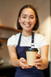 微笑的美如一家咖啡会女孩 给外送咖啡杯 准备请客餐饮的外卖订单 穿着围裙制服职场女性工作食堂广告酒吧房子命令服务员职业图片