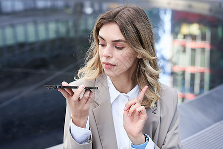 商业女商务人士记录语音信息 在移动电话上发布某种内容 在智能手机应用程序上做一个注解图片