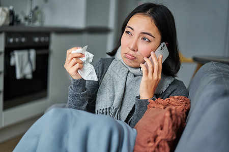 生病妇女打给诊所 与全科医生联系电话预约 感冒和呆在家中等病人的肖像组织长椅疾病成人发烧女性温度计鼻子感染疼痛图片