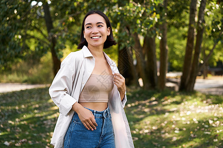 战争与和平时尚的像亚洲女孩走在公园里 笑笑和享受夏季天气 人与生活方式概念治疗学生福利黑发自由喜悦女性微笑假期快乐背景