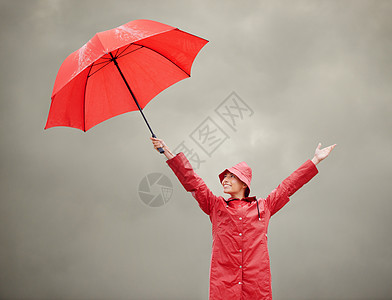 保持积极性 一个美丽的年轻女子拿着她的红伞站在外面图片