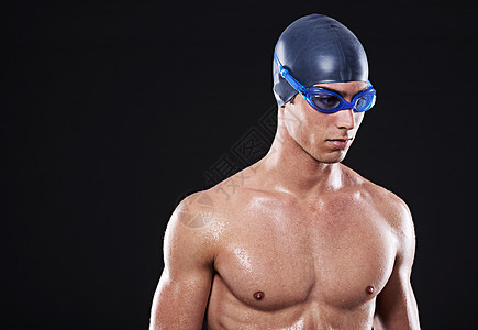 以成功为主 工作室肖像画 一个年轻的男性游泳运动员 带着护目镜和帽子图片