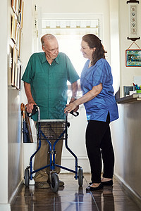 她提供最好的老年护理 一名全时的女护士协助其高级男性病人用助行器做陪护图片