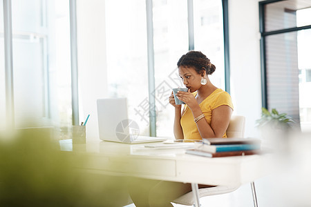 咖啡休息是为了在社交媒体上追赶 一位年轻女商务人士使用笔记本电脑 在现代办公室的办公桌上喝饮料图片