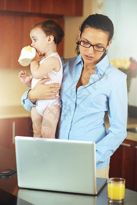 母性是全职工作 一个忙碌的年轻母亲带着孩子在家图片
