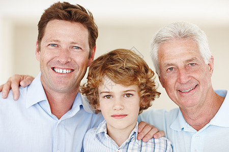 他们有特殊的联系 一个小男孩与他的父亲和祖父站在一起的裁剪肖像图片