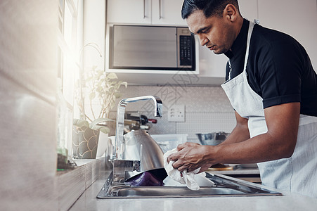 清洁厨房 洗碗和一个人在家里 家里或公寓里清洁 以确保安全免受细菌侵害 为了卫生和健康的生活方式 洗手池里的男清洁工手里拿着一块图片
