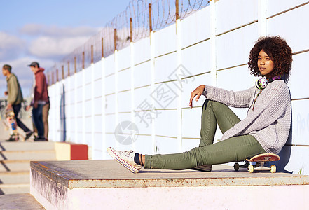 我最喜欢的地方 一位年轻女子坐在滑板上 在溜冰场玩耍图片