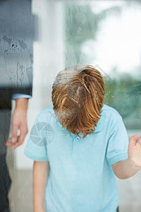 我想到外面去 一个年轻男孩在下雨时 头朝窗边看望着他的头图片