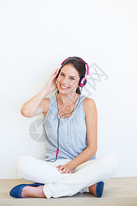 在工作室的地板上为女性准备的音乐 肖像和耳机 在背景墙上快乐地流动着 面部 微笑和女孩坐在模型旁 通过播客 广播或音轨放松图片