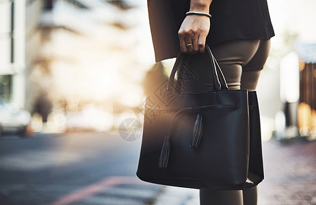 有个女商务人士带着手提包在城里行走的近距离拍到一张照片 她拿着手提包在城里散步图片