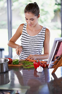 健康是今晚的菜单 一个年轻女人在厨房做饭蔬菜低碳水胡椒回发女性化合物食谱有机食品消耗品烹饪图片