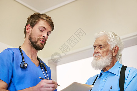 让我确定我有你所有的症状 一位年轻的医生和他年长的病人一起讨论他的病历图片