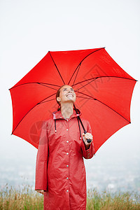 如果下雨了 我什么都准备就绪 一位美丽的年轻女士站在外边拿着她的红伞站着图片