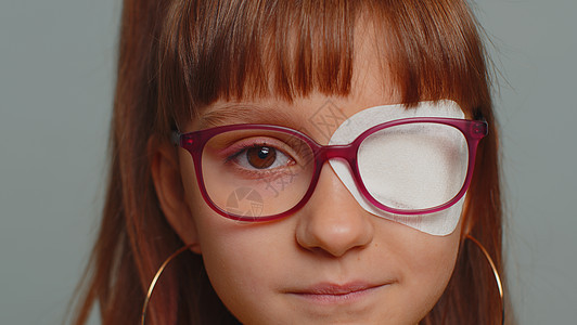 年幼生病的女童在看照相机 一只眼睛上有保护性绷带贴着石膏擦痕图片