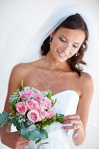 欣赏她的花束 一位美丽的年轻新娘拿着她的花束图片