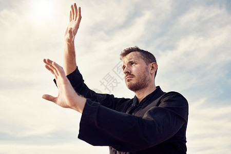 空手道男子 在多云的天空下健身和锻炼 用镜头光晕进行精神锻炼 武术和户外训练 准备用手打太极拳 气功或跆拳道的运动员男性图片