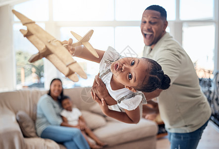 父亲 女孩或在家里或客厅里玩玩具飞机 以获得令人兴奋的游戏 旅行梦想或幻想 俏皮的肖像 飞机或有趣的孩子与男人 爸爸或举重的父母图片