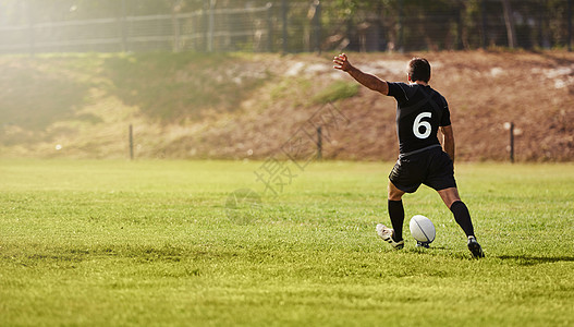 在户外练习 锻炼或训练期间 橄榄球 球员和踢运动球 运动员 运动员和男子在比赛中为夏日的冠军赛点球图片