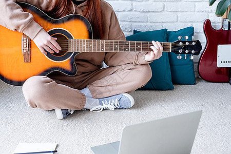年轻女子在家弹吉他时学习在家里弹吉他快乐成人歌曲音乐家女孩乐器闲暇艺术家青少年女性图片