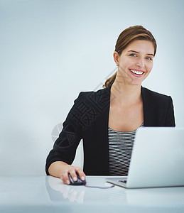 一位在笔记本电脑上工作的年轻女商务人士的演播室肖像商业成年人员工女性网络商务公司女士技术互联网图片